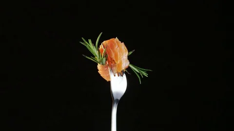 Rotating Fork With Salmon and Rosemary on Black Background Stock Footage 70540551