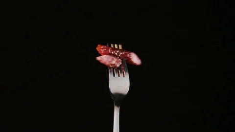Rotating Fork With Two Dry Pork Sausages on Black Background Stock Footage 70539716
