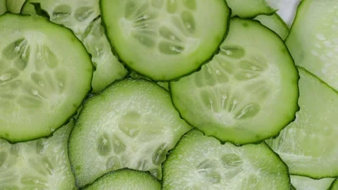 Rotating fresh cucumber slices in circular motion. macro video of raw green Stock Footage 314363645
