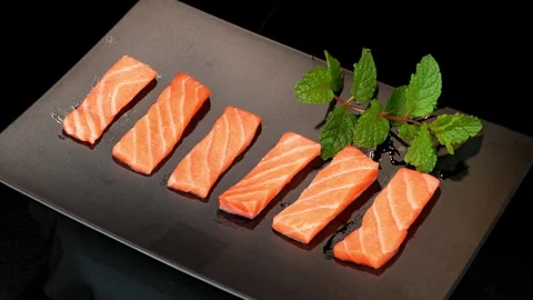 Rotating Fresh Salmon Sashimi Slices on Black Plate Stock Footage 342621796