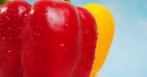 Rotating fresh three bell peppers red, yellow, green on blue background Stock-Footage 160092389