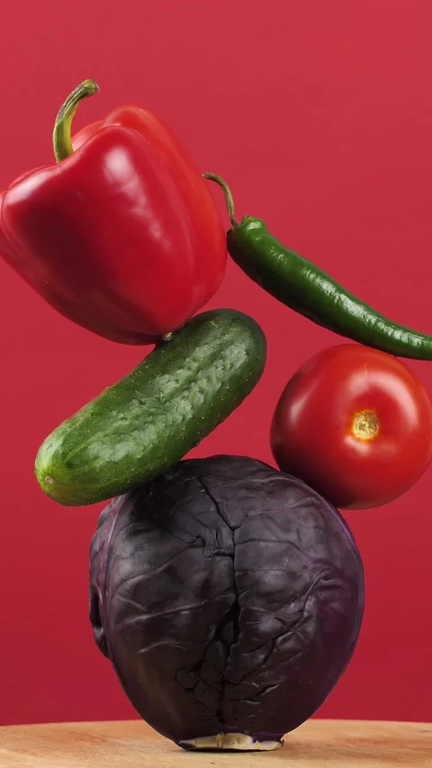 Rotating fresh vegetables on a red background. Creative food concept Stock Footage 308045976