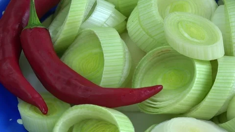 Rotating freshly chopped leeks and red hot chili peppers Stock Footage 122741119