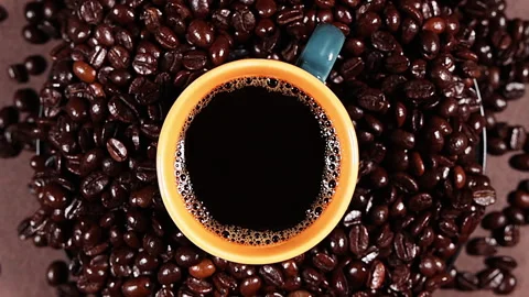 Rotating freshly poured coffee over the coffee beans Stock Footage 252655478