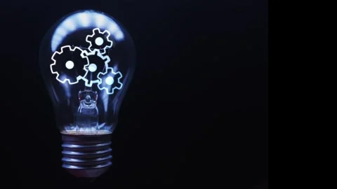 Rotating gears inside a light bulb in which the light turns on and off on a Stock Footage 270708686
