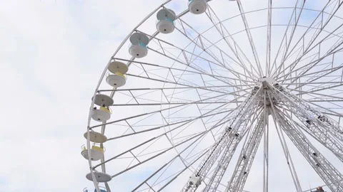 Rotating Giant Ferris Wheel at daytime with cloudy sky background - Static Stock Footage 166012270