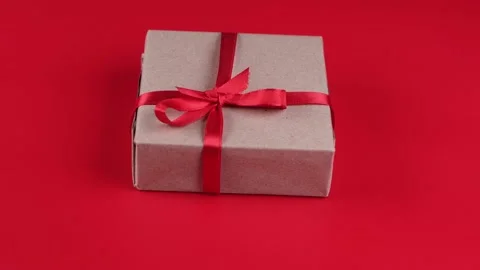 Rotating gift box with red ribbon and bow on red background. Concept for lovers Stock Footage 167444270