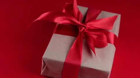 Rotating gift box with red ribbon and bow on red background. Concept for lovers Stock Footage 168160548