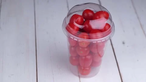 Rotating glass with cherry tomatoes on white wooden boards healthy food concept Stock Footage 167559991