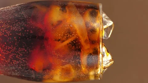 Rotating glass of cola with ice cubes. Cola with ice and bubbles in a glass Stock Footage 247667785