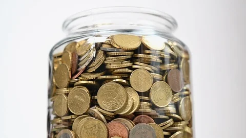 Rotating glass jar full of small savings Stock Footage 127127057