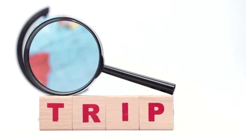 Rotating globe through the magnifying glass, wooden cubes create word trip Stock Footage 236285780