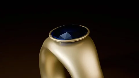 Rotating gold signet ring with camera pulling back revealing bezel-set gem for Stock Footage 339194299