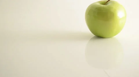 Rotating Granny Smith Apple On Acrylic Against White - Crane Up Stock Footage 24469767