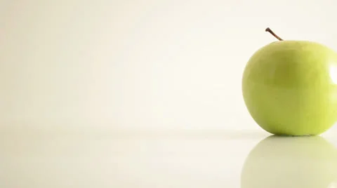 Rotating Granny Smith Apple On Acrylic Against White - Dolly Left Stock Footage 24470565