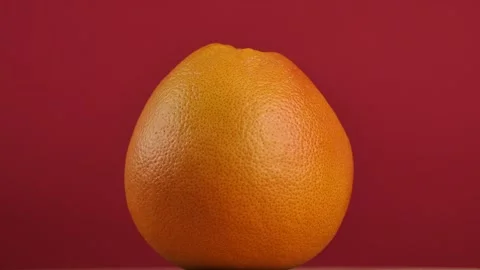 Rotating grapefruit on red background Stock Footage 273834454