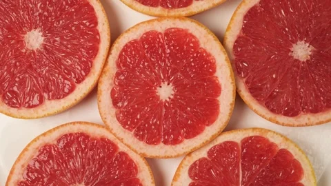 Rotating grapefruit slices on a white background Stock Footage 340159905