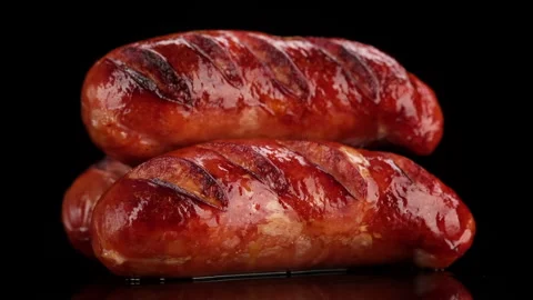Rotating grilled sausage on black background Stock-Footage 132945249
