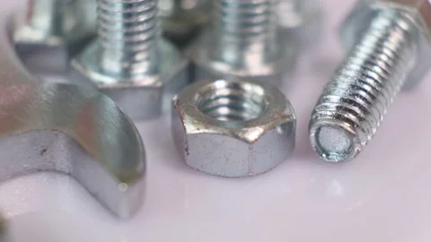 Rotating group of galvanized metallic screws , wrench and nut close-up. Stock Footage 140876605