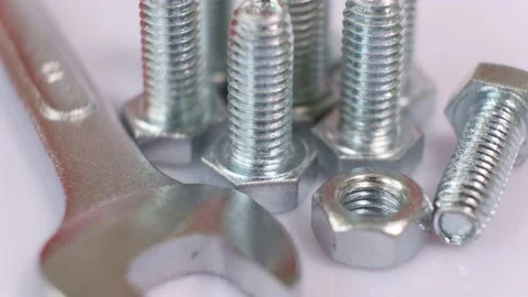 Rotating group of galvanized metallic screws , wrench and nut close-up. Stock Footage 141023653
