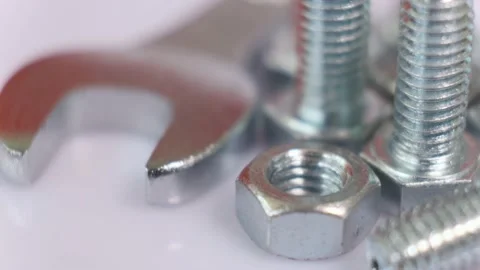 Rotating group of galvanized metallic screws , wrench and nut close-up. Stock Footage 141333105