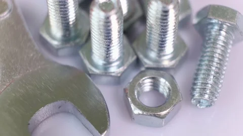 Rotating group of galvanized metallic screws , wrench and nut close-up. Stock Footage 141498083