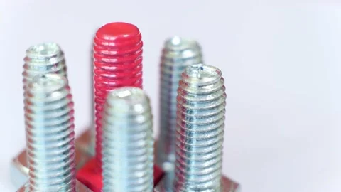 Rotating group of metallic screws close-up, one of them is pink colored. Stock Footage 141876925