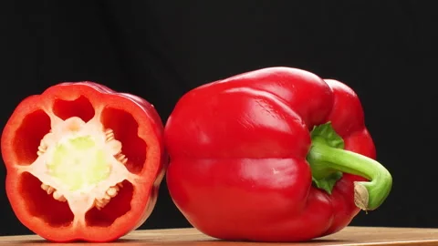 Rotating Half And Whole Red Bell Pepper On Wooden Board Black Background Stock Footage 325564838