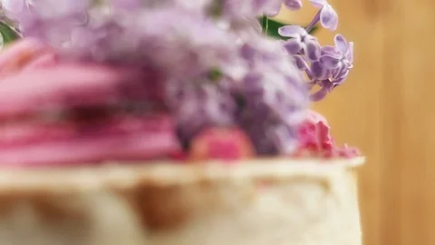 Rotating handmade cake decoration with macaroons, strawberries and lilac, 4K Stock Footage 99320471