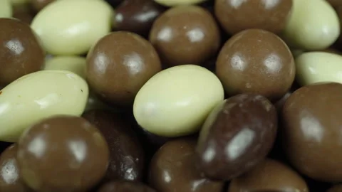 Rotating Hazelnuts And Almonds Covered In Chocolate Glaze Closeup. Video stock 229464974