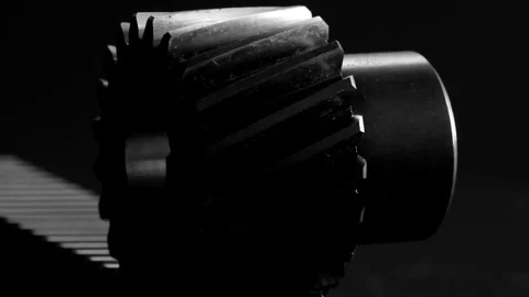 Rotating helical gear rack and a pinion on black background Stock Footage 83832402