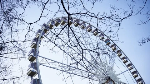 Rotating illuminated ferris wheel from below with passenger gondolas suspended o Video stock 100273768