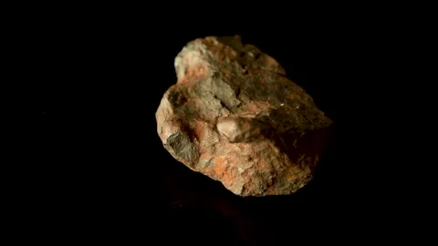 Rotating Of An Iron Meteorite. black background on a mirror base. general pla Stock Footage 231555944