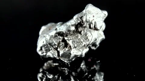 Rotating Of An Iron Meteorite. black background on a mirror base. Close-up. M Stock Footage 231557797