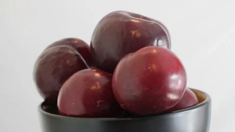 Rotating large black plums in a deep bowl. Stock Footage 159192874
