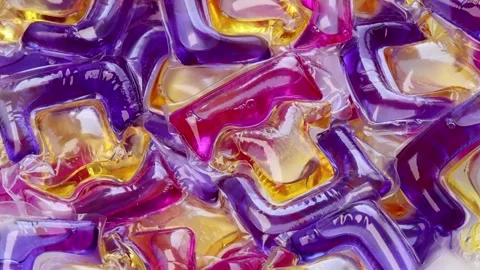 Rotating laundry detergent pods, colorful liquid capsules spinning in circle. Video stock 311237485