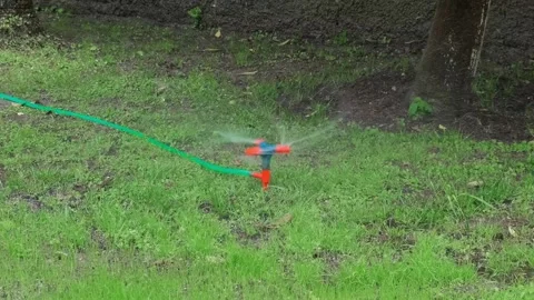Rotating lawn sprinkler, close-up Stock Footage 334856563