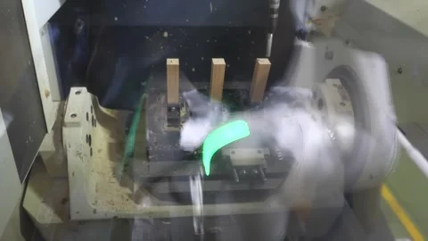 Rotating Machine Fixture Turning a Blade Through Coolant Mist Stock Footage 340900268
