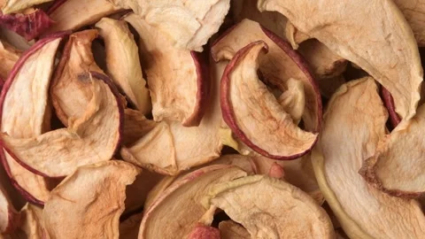 Rotating macro of dried apple slices and chips as natural snack texture Stock Footage 326893700