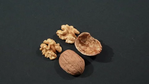 Rotating Macro Two Walnut Kernels and Empty Shells Stock Footage 332524972