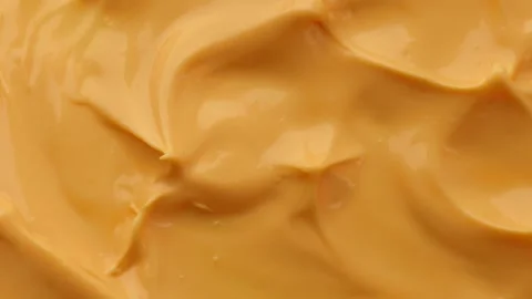 Rotating mango sauce in circular motion on white background, vibrant golden Stock Footage 310338675