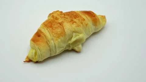 Rotating mini croissant on white background. Stockbeeldmateriaal 245876124