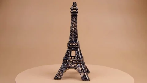 Rotating miniature or souvenir of the Eiffel Tower on a beige background Stock Footage 196979226