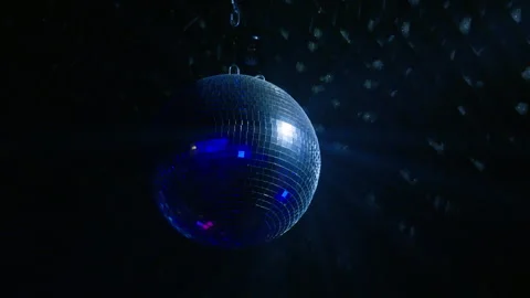 Rotating Mirror Disco Ball with Blue Light Flashes in Dark Nightclub Stock Footage 334593360
