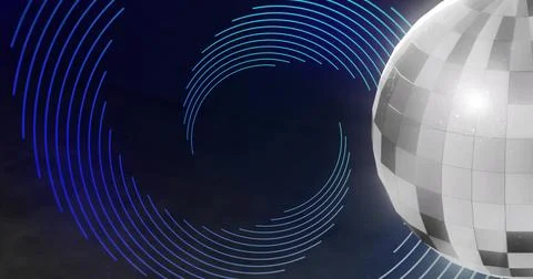 Rotating mirrored disco ball casting bright glow on stage with neon rings, Stock Photos