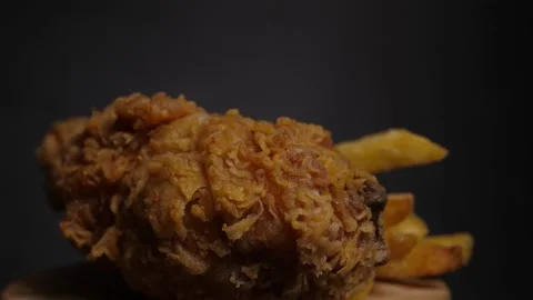Rotating motion of a fried chicken and french fries close up Stock Footage 160560714