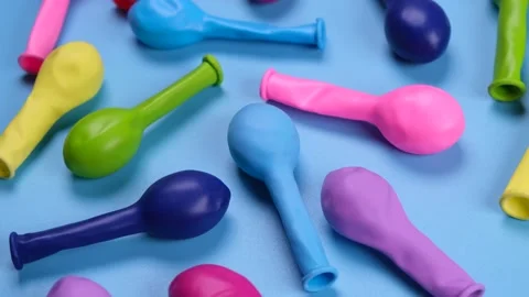 Rotating multi-colored balloons on a blue background, top view, the concept of Stock Footage 217360711
