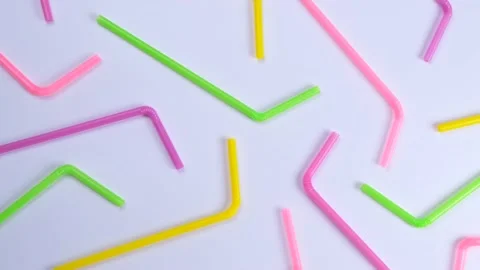 Rotating multi-colored cocktail straws on a white background, top view, the Stock Footage 211051586