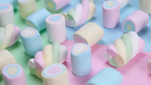 Rotating multicolored chewy marshmallows on a multicolored background, the Stock Footage 200003730
