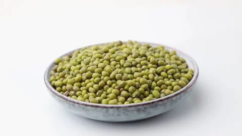 Rotating of mung beans in ceramic plate on white background. Side view. Stock Footage 136050430
